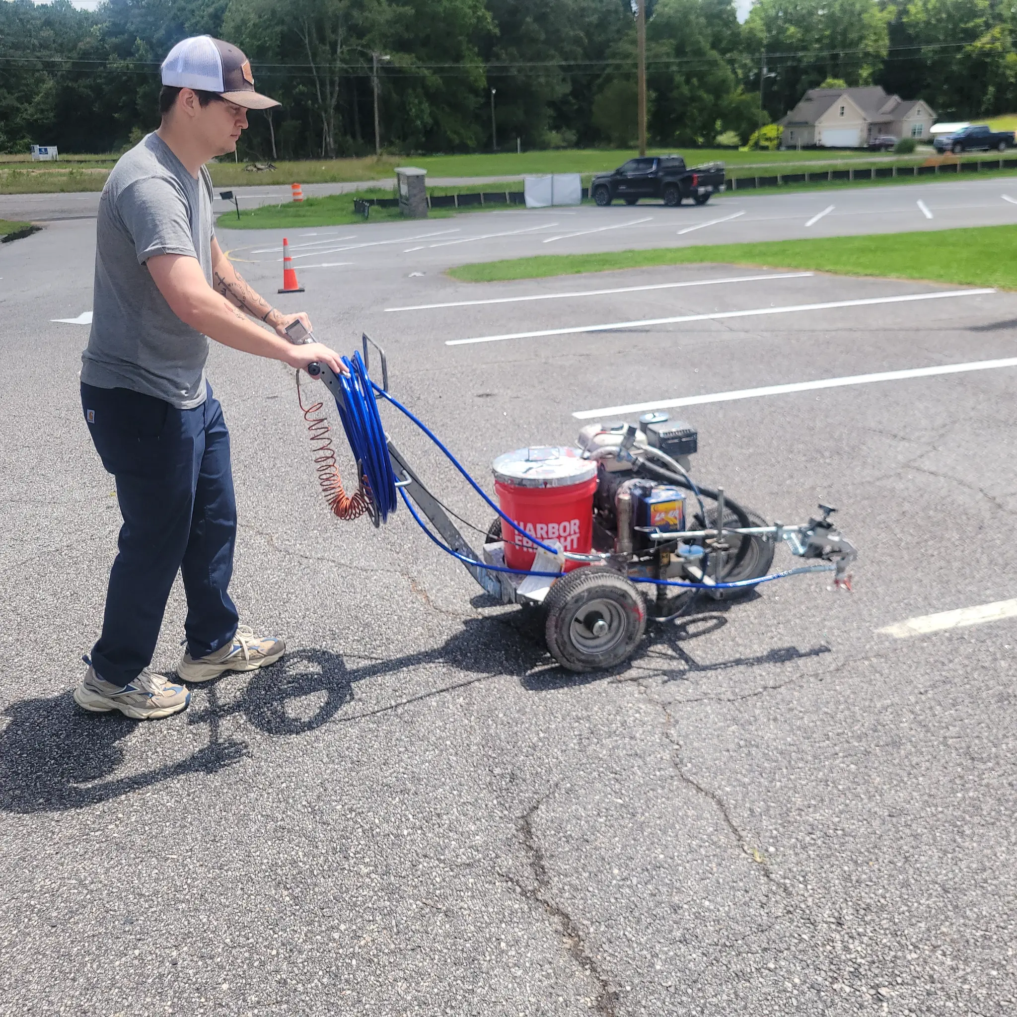 RoseCreek Striping crew member operating line striping equipment at a North & Middle Georgia commercial parking lot.